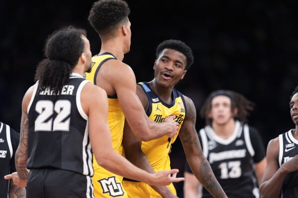 Marquette forward Oso Ighodaro, second from left, pulls guard Kam Jones away as he Jones argues with Providence guard Devin Carter (22) during the second half of an NCAA college basketball game in the semifinals of the Big East men's tournament Friday, March 15, 2024, in New York. Marquette won 79-68. (AP Photo/Mary Altaffer)