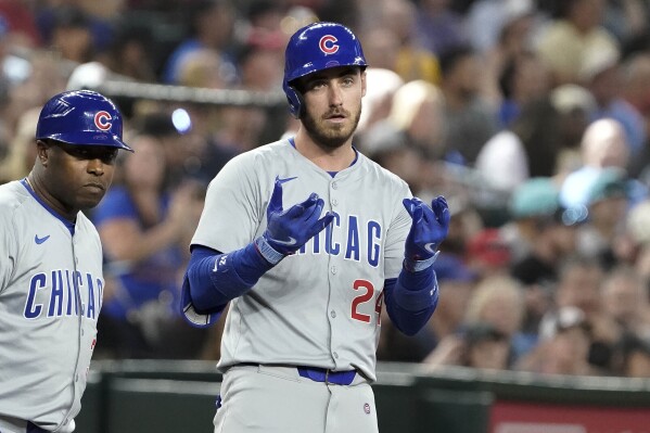 Chicago Cubs' Cody Bellinger (24) gestures towards the dugout after reaching third base against the Arizona Diamondbacks during the eight inning of a baseball game Wednesday, April 17, 2024, in Phoenix. (AP Photo/Darryl Webb)