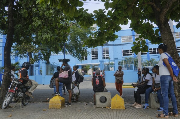 People wait outside at Nuestra Señora de la Altagracia Maternity Hospital in Santo Domingo, Dominican Republic, Sunday, Dec. 10, 2023. The Dominican Republican criminalizes abortion without exceptions and women face up to 2 years in prison for having an abortion. Penalties for doctors or midwives range from 5 to 20 years. (AP Photo/Ricardo Hernandez)