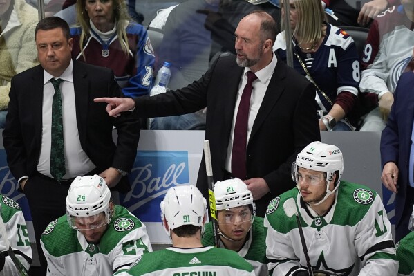 Dallas Stars coach Peter DeBoer, back right, directs players during the third period of Game 3 of the team's NHL hockey Stanley Cup playoff series against the Colorado Avalanche on Saturday, May 11, 2024, in Denver. (AP Photo/David Zalubowski)