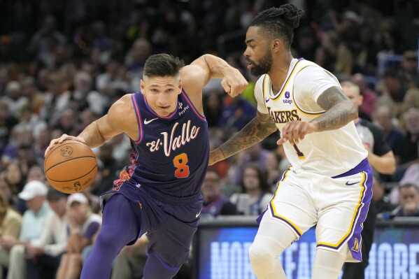 Phoenix Suns guard Grayson Allen (8) drives against Los Angeles Lakers guard D'Angelo Russell, right, during the second half of an NBA basketball game, Sunday, Feb. 25, 2024, in Phoenix. (AP Photo/Rick Scuteri)