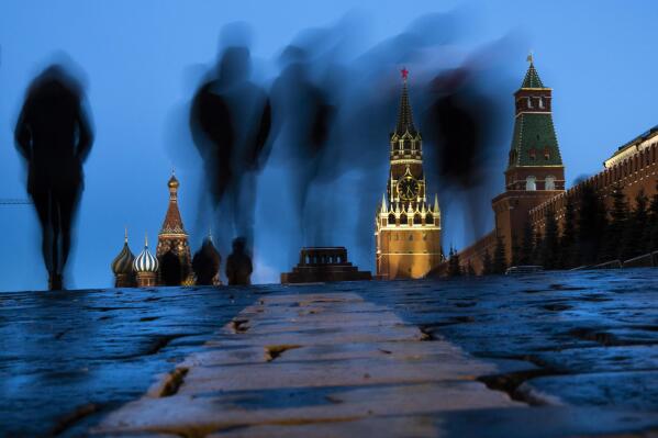FILE - People walk through Red Square after sunset in Moscow, Russia, on March 3, 2019, with the St. Basil's left, and the Spasskaya Tower, second right, in the background. Russian technology workers are fleeing the country by the tens of thousands as the economy goes into a tailspin under pressure from international sanctions. For some countries, Russia’s loss is being seen as their potential gain and an opportunity to bring fresh expertise to their own high-tech industries. (AP Photo/Alexander Zemlianichenko, File)