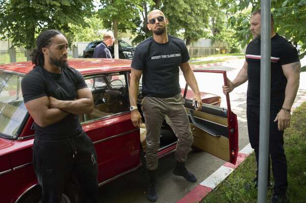 Andrew Tate arrives at a police station in a Lada vehicle in Voluntari, Romania, Wednesday, May 21, 2025. (AP Photo/Vadim Ghirda)