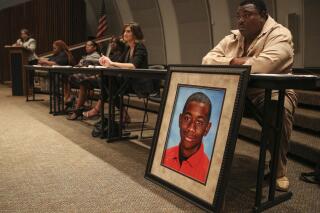 FILE - Andrew Joseph Jr. sits behind a picture of his deceased son, Andrew Joseph III, at a Black Lives Matter forum at John Germany Library in Tampa, Fla., on Wednesday, Sept. 9, 2015.  A Florida sheriff has been ordered by a jury to pay $15 million to the parents of Andrew Joseph III, a teenager who died while trying to cross a highway after being kicked out of the state fair by deputies. The 10-person jury reached its verdict Thursday, Sept. 22, 2022.  (Loren Elliott/Tampa Bay Times via AP)