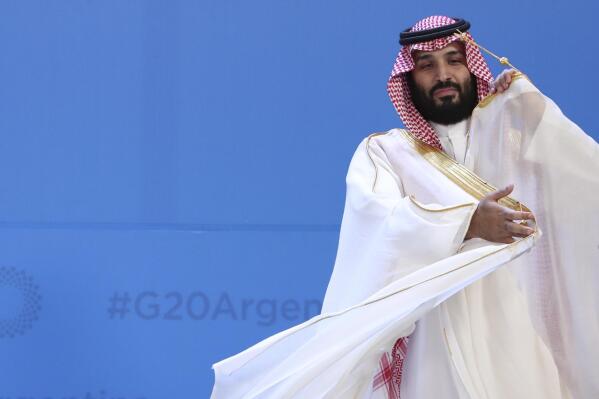 FILE - Saudi Arabia's Crown Prince Mohammed bin Salman adjusts his robe as leaders gather for the group at the G20 Leader's Summit at the Costa Salguero Center in Buenos Aires, Argentina, Nov. 30, 2018. Saudi Arabia's powerful 37-year-old crown prince will not attend an upcoming summit in Algeria after his doctors advised him not to travel, the Algerian presidency said early Sunday, Oct. 23, 2022. (AP Photo/Ricardo Mazalan, File)