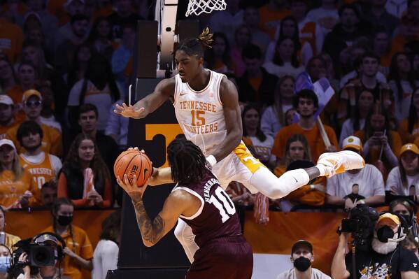 Tennessee guard Jahmai Mashack (15) flies over Texas A&M guard Aaron Cash (0) while defending during the first half of an NCAA college basketball game Tuesday, Feb. 1, 2022, in Knoxville, Tenn. (AP Photo/Wade Payne)