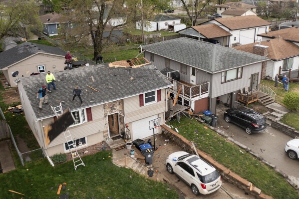 Des voisins aident à nettoyer la maison de Justin et Amanda Putnam après qu'une violente tempête ait balayé la région de Council Bluffs, Iowa, le vendredi 26 avril 2024. (Anna Reed/Omaha World-Herald via AP)