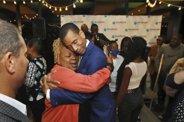 Malik Evans gets an emotional hug from his wife Shawanda Evans' aunt Kimberly Flint as he celebrates with supporters after his win in the Democrat primary race for Rochester Mayor, beating two-term incumbent Lovely Warren, in downtown Rochester, N.Y., Tuesday, June 22, 2021. (Shawn Dowd/Democrat & Chronicle via AP)
