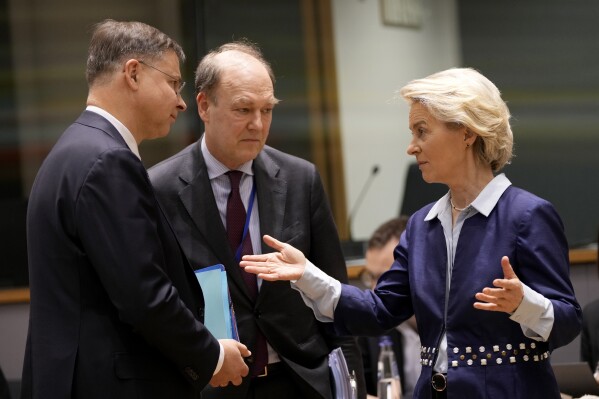 European Commission President Ursula von der Leyen, right, speaks with European Commissioner for An Economy that Works for People Valdis Dombrovskis, left, during the tripartite social summit at the European Council building in Brussels, Wednesday, March 20, 2024. (AP Photo/Virginia Mayo)