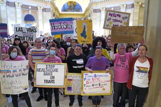 FILE - Trans-rights activists protest outside the House chamber at the Oklahoma Capitol before the State of the State address, Feb. 6, 2023, in Oklahoma City. On Monday, May 1, Oklahoma became the latest state to ban gender-affirming medical care for minors as Republican Gov. Kevin Stitt signed a bill that makes it a felony for health care workers to provide children with treatments that can include puberty-blocking drugs and hormones. (AP Photo/Sue Ogrocki, File)