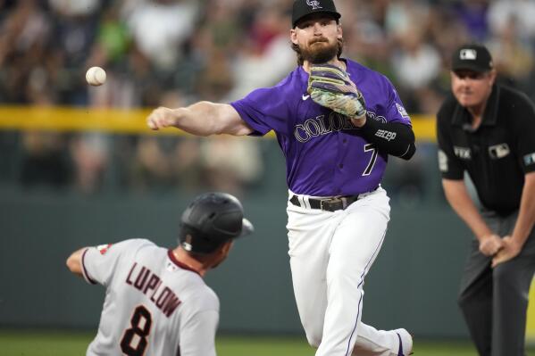 Colorado Rockies second baseman Brendan Rodgers throws over Arizona Diamondbacks' Jordan Luplow after forcing him out at second base on the front end of a double play hit into by Cooper Hummel during the sixth inning of a baseball game Saturday, July 2, 2022, in Denver. (AP Photo/David Zalubowski)