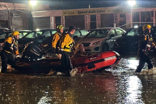 In this image provided by Pittsburgh Public Safety, Pittsburgh area water rescue team rescued a woman trapped in a car sinking in rising waters along a section of Route 51 east of the city Thursday night, April 11, 2024, in Pittsburg. Flash flooding caused by relentless heavy rains that soaked western Pennsylvania spurred numerous rescues and evacuations in the region, but no injuries were reported. (Pittsburgh Public Safety via AP)
