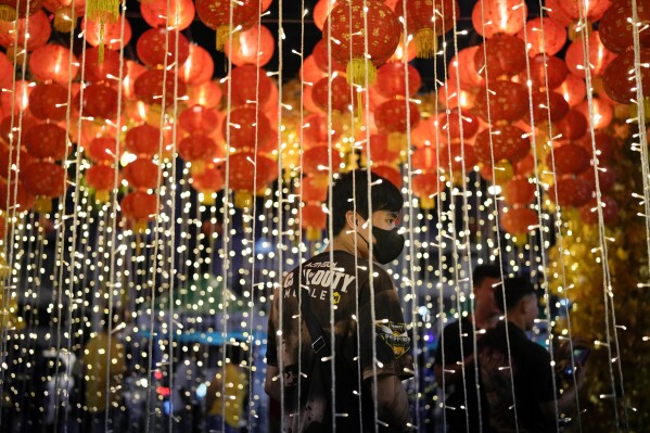 A man stands under lanterns during an event for the 430th anniversary of Manila's Chinatown, said to be the oldest in the world, at the capital's Binondo district, Philippines on Thursday, Feb. 1, 2024. Crowds are flocking to Manila's Chinatown to usher in the Year of the Wood Dragon and experience lively traditional dances on lantern-lit streets with food, lucky charms and prayers for good fortune. (AP Photo/Aaron Favila)