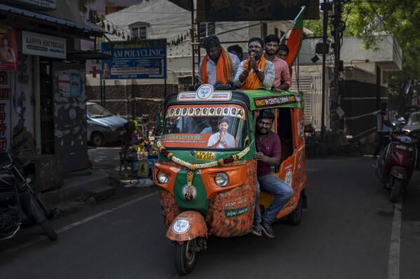 Supporters of Bharatiya Janata Party ride an auto rickshaw during a roadshow in support of their candidate Vinoj Selvam during an election campaign rally ahead of country's general elections, on the outskirts of southern Indian city of Chennai, April 16, 2024. (AP Photo/Altaf Qadri)