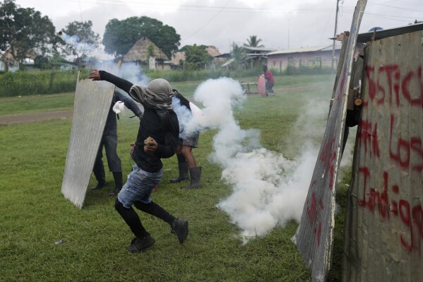 Anti-government protesters throw back a tear gas canister during a clash with police in the Indigenous Embera community of Alimaye, Panama on Thursday, June 5, 2025.