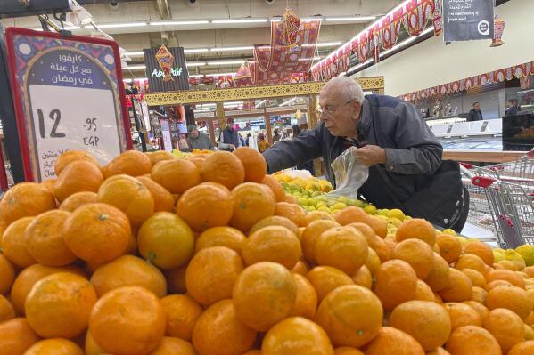 An Egyptian buys fruits at a supermarket in Cairo, Egypt, Sunday, Feb. 26, 2023. Annual inflation reached 26.5% in January, the highest in five years, and food prices in urban areas soared 48% last month, according to official figures. But the price increases consumers see in markets and grocery stores are much steeper. (AP Photo/Amr Nabil)