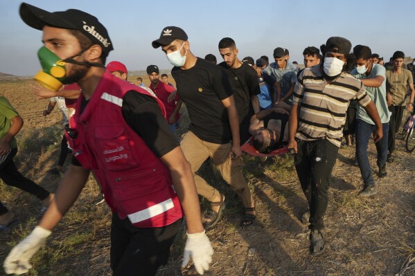 Palestinian protesters evacuate a wounded youth during clashes with Israeli security forces along the frontier with Israel, east of Gaza City, Friday, Sept. 22, 2023. The Israeli military said it struck three posts belonging to Hamas, the Islamic militant group that has controlled Gaza since 2007, following a number of incendiary balloons launched from Gaza into Israel. This is the latest violence to roil the territory as Palestinians stage routine protests by the border fence. (AP Photo/Adel Hana)