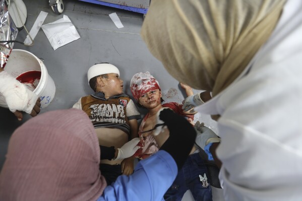 Palestinian children wounded in the Israeli bombardment of the Gaza Strip are treated in al-Aqsa Hospital in Deir al Balah, Sunday, June 9, 2024. (AP Photo/Saher Alghorra)