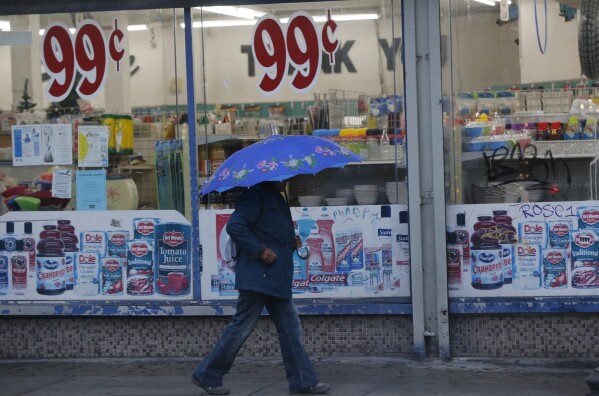 FILE - A pedestrian walks past a 99 Cents Only store under light rain in Los Angeles Wednesday, Dec. 5, 2018. Dollar Tree is planning to reopen some 99 Cents Only stores that have closed, rebranding them and filling them with their own products. Dollar Tree said that the 170 stores are located in Arizona, Texas, California and Nevada. (AP Photo/Damian Dovarganes, File)