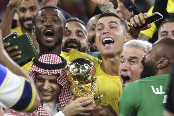 Al Nassr's Cristiano Ronaldo, and teammates celebrate with the trophy of the Arab Club Championship Cup at King Fahd Stadium in Taif, Saudi Arabia, Saturday, Aug.12, 2023. (AP Photo/Samah Zidan)