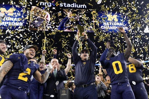 Michigan head coach Jim Harbaugh celebrates with the trophy after their win against Washington in the national championship NCAA College Football Playoff game Monday, Jan. 8, 2024, in Houston. (AP Photo/David J. Phillip)