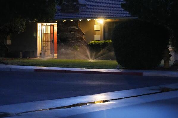 Sprinklers water a lawn at a home Thursday, June 8, 2023, in Las Vegas. Nevada Gov. Joe Lombardo signed a law this week, following passage by the Democratic-controlled Legislature, that would let the Southern Nevada Water Authority cap residential water flows in the future if the federal government dials back Nevada's share of water drawn from the drought-stricken Lake Mead reservoir. (AP Photo/John Locher)