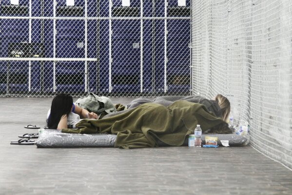 Migrants are detained in a tented, air-conditioned cage at a Border Patrol detention facility in Tornillo, Texas,  Thursday, Aug. 15, 2019. Immigration officials say that with less detainees and more detention space, migrants apprehended along the U.S.-Mexico border won’t be subject to the squalid, overcrowded conditions criticized earlier this year. (AP Photo/Cedar Attanasio)