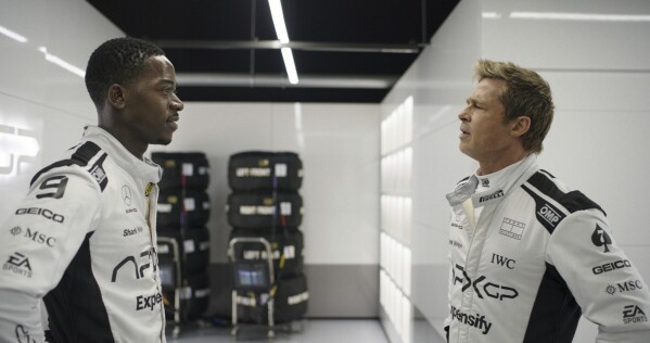 This image released by Apple TV+ shows Damson Idris as Joshua Pearce, left, and Brad Pitt as Sonny Hayes in a scene from "F1 The Movie." (Apple TV+ via AP)