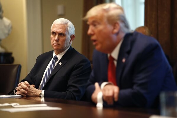 President Donald Trump speaks as Vice President Mike Pence listens during a meeting with supply chain distributors in the Cabinet Room of the White House, Sunday, March 29, 2020, in Washington. (AP Photo/Patrick Semansky)