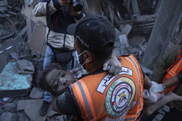 Palestinians evacuate wounded from a building destroyed in Israeli bombardment in Khan Younis, Gaza Strip, Thursday, Oct. 19, 2023. (AP Photo/Fatima Shbair)