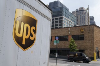 FILE - A delivery vehicle passes by a UPS depot, Thursday, June 29, 2023, in New York. UPS has received an air cargo contract from the United States Postal Service, significantly expanding on an existing partnership between the two. UPS said Monday, April 1, 2024, that it will become USPS's primary air cargo provider and move the majority of its air cargo in the U.S. following a transition period.(AP Photo/John Minchillo, File)