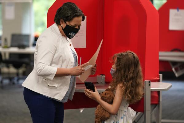 Democratic gubernatorial candidate, Virginia State Sen. Jennifer McClellan, left, shows her daughter Samantha, right, her ballot at an early voting location in Richmond, Va., Saturday, May 29, 2021. McClellan faces four other Democrats in the primary.  (AP Photo/Steve Helber)