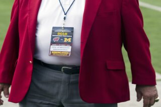 FILE - Wisconsin athletic director Barry Alvarez is shown on the field before an NCAA college football game against Michigan at Michigan Stadium in Ann Arbor, Mich., in this Saturday, Oct. 1, 2016, file photo. Wisconsin athletic director Barry Alvarez is retiring after a three-decade run in which he transformed the university’s football program and later guided the Badgers to their greatest all-around sports success in the school’s history. Alvarez announced Tuesday, April 6, 2021, he would retire on June 30.(AP Photo/Tony Ding, File)