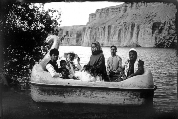 The Moradi family sits for a portrait on a small boat in Band-i-Mir lake, one of the tourist attractions in the Bamiyan Valley region in Afghanistan, Saturday, June 17, 2023. The family traveled a long way from Helmand to spend a few days for their summer vacation. During their first stint in power from 1996 to 2001, the Taliban banned photography of humans and animals as contrary to the teachings of Islam. On Aug. 26, 2023 they banned all women from entering all national parks including Band-i-Mir, in a move that has triggered widespread condemnation.(AP Photo/Rodrigo Abd)