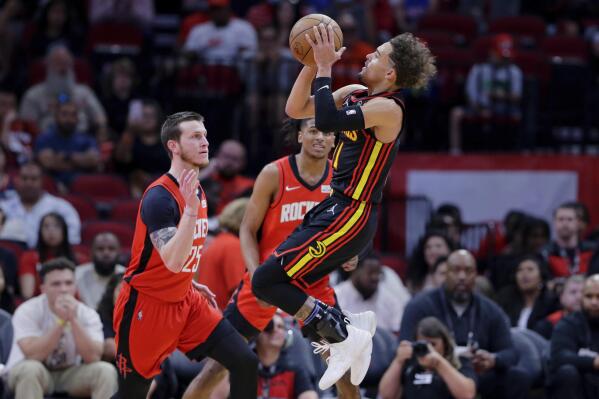 Atlanta Hawks guard Trae Young, right, puts up a shot over Houston Rockets guards Garrison Mathews (25) and Jalen Green, back, during the second half of an NBA basketball game Sunday, April 10, 2022, in Houston. (AP Photo/Michael Wyke)