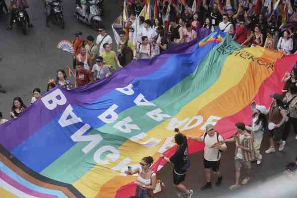 Participants hold a rainbow flag during the annual Pride Parade to celebrate the LGBTQ+ community’s Pride Month in Bangkok, Thailand, Sunday, June 1, 2025. (AP Photo/Sakchai Lalit)