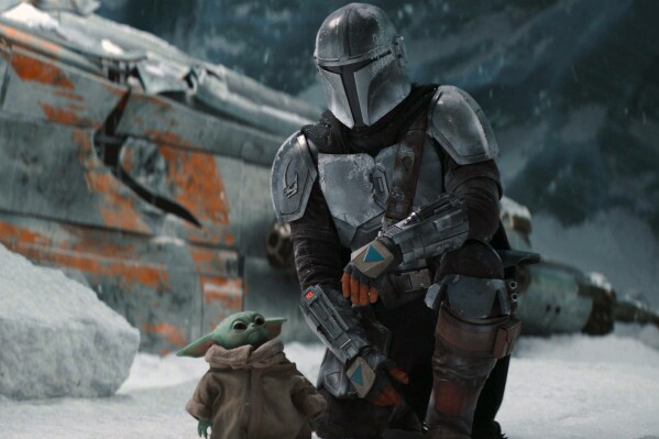 This image released by Disney+ shows Pedro Pascal in a scene from "The Mandalorian." Jon Favreau is set to direct the film “The Mandalorian & Grogu” which will go into production this year, Lucasfilm and Disney announced Tuesday. (Disney+ via AP)