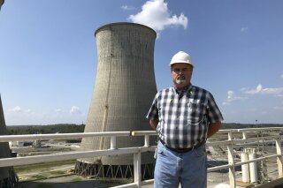 Steve Holland, general manager of the Paradise Fossil Plant, stands near one of the plant's cooling towers in Drakesboro, Ky., on Sept. 12, 2019. Holland oversaw the Tennessee Valley Authority plant as it burned its last load of coal and shut down in February. (AP Photo/Dylan Lovan)