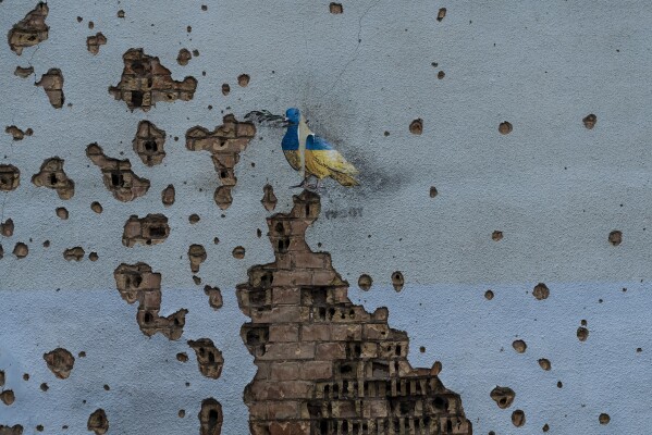 A dove painted by artist TvBoy adorns the wall of a building damaged by Russian shelling attacks in Irpin, Ukraine, Friday, July 7, 2023. (AP Photo/Jae C. Hong)