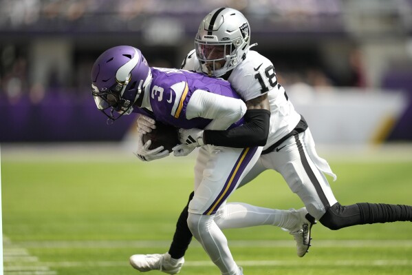 Minnesota Vikings wide receiver Jordan Addison (3) is hit by Las Vegas Raiders cornerback Jack Jones (18) after making a catch during the first half of an NFL football game Saturday, Aug. 10, 2024, in Minneapolis. (AP Photo/Charlie Neibergall)