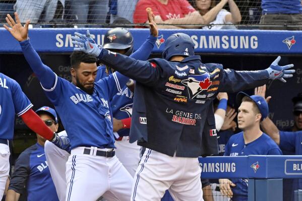 Toronto Blue Jays' George Springer, right, celebrates with Teoscar Hernandez, left, after hitting a solo home run in the second inning of a baseball game against the Baltimore Orioles in Toronto on Saturday, Oct. 2, 2021. (Jon Blacker/The Canadian Press via AP)