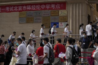 FILE - Students line up to enter a school for the first day of China's national college entrance examinations, known as the gaokao, in Beijing, Tuesday, June 7, 2022. After the pandemic, young Chinese are again looking to study abroad. But the decades-long run that has sent an estimated 3 million Chinese students to the U.S. could be trending down. (AP Photo/Andy Wong, File )