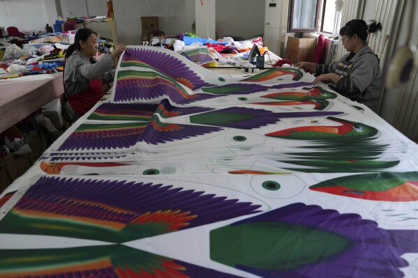 Workers prepare kites at workshop in Weifang, Shandong Province of China, Friday , April 19, 2024. (AP Photo/Tatan Syuflana)
