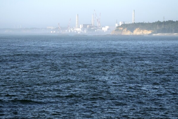 FILE - The Fukushima Daiichi nuclear power plant, damaged by a massive March 11, 2011, earthquake and tsunami, is seen from the nearby Ukedo fishing port in Namie town, northeastern Japan, on Aug. 24, 2023. The release of a third batch of treated radioactive wastewater from Japan's damaged Fukushima nuclear plant into the Pacific Ocean ended safely as planned, its operator said Monday, Nov. 20, as the country's seafood producers continue to suffer from a Chinese import ban imposed after the discharges began. (AP Photo/Eugene Hoshiko, File)