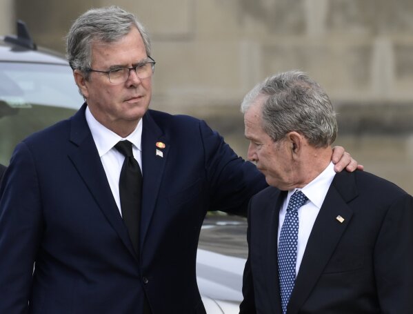 
              Former Florida Gov. Jeb Bush, left, reaches out to his brother, former President George W. Bush, right, as they arrive to watch the casket of former President George H.W. Bush arrive for a State Funeral at the National Cathedral, Wednesday, Dec. 5, 2018, in Washington. (AP Photo/Susan Walsh)
            