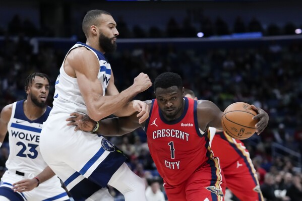 New Orleans Pelicans forward Zion Williamson (1) drives to the basket against Minnesota Timberwolves center Rudy Gobert in the first half of an NBA basketball game in New Orleans, Monday, Dec. 11, 2023. (AP Photo/Gerald Herbert)