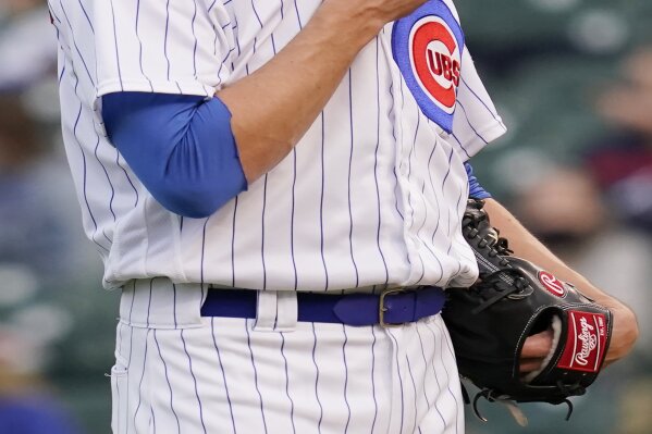 Chicago Cubs starting pitcher Kyle Hendricks wipes his face after Atlanta Braves' Ehire Adrianza hit a solo home run during the first inning of a baseball game in Chicago, Sunday, April 18, 2021. (AP Photo/Nam Y. Huh)