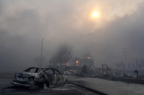 A burned-out car sits among rubble in the downtown Altadena section of Pasadena, Calif., Wednesday, Jan. 8, 2025. (AP Photo/Chris Pizzello)