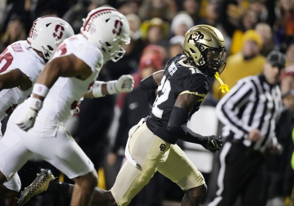 Colorado wide receiver Travis Hunter, right, gets away Stanford safety Alaka'i Gilman, front left, and cornerback Jaden Slocum on the way to scoring a touchdown during the first half of an NCAA college football game Friday, Oct. 13, 2023, in Boulder, Colo. (AP Photo/David Zalubowski)