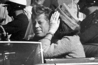 FILE - In this Nov. 22, 1963 file photo, President John F. Kennedy waves from his car in a motorcade in Dallas. Riding with Kennedy are First Lady Jacqueline Kennedy, right, Nellie Connally, second from left, and her husband, Texas Gov. John Connally, far left. The term "conspiracy theory" was used well before Kennedy's assassination, evidence shows. (AP Photo/Jim Altgens, File)